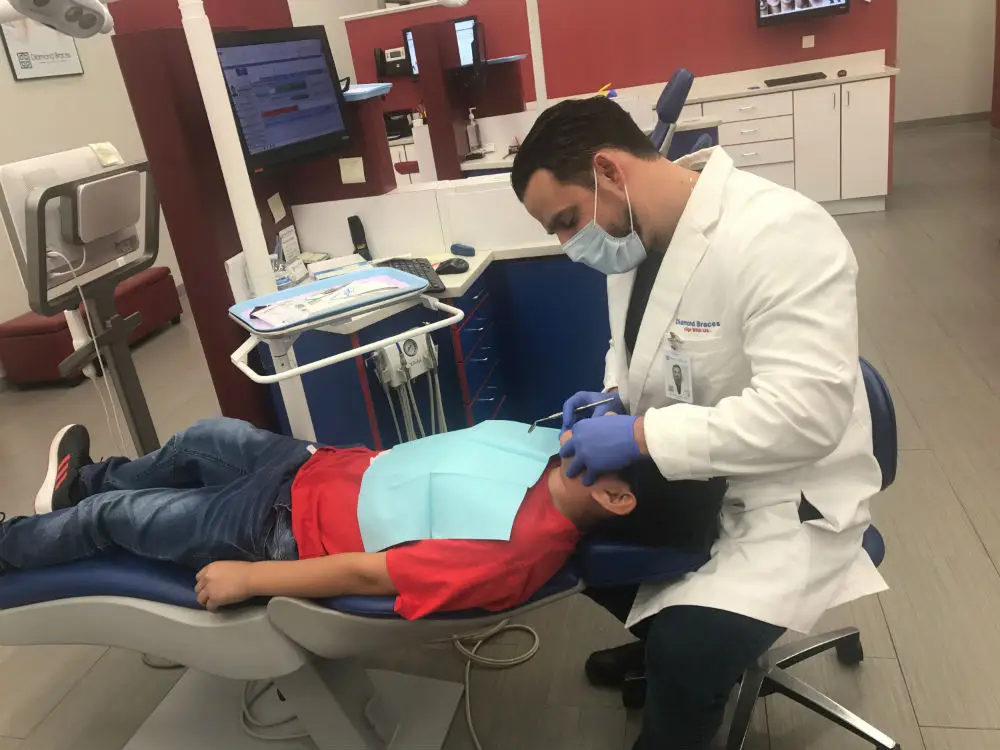 Ortodoncista cuidando al paciente con Brackets
