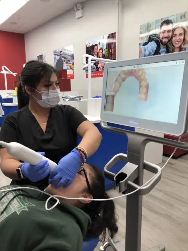 asistente dental escanea paciente con escáner digital