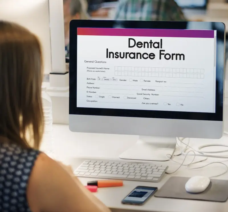 Woman at computer signing up for dental insurance
