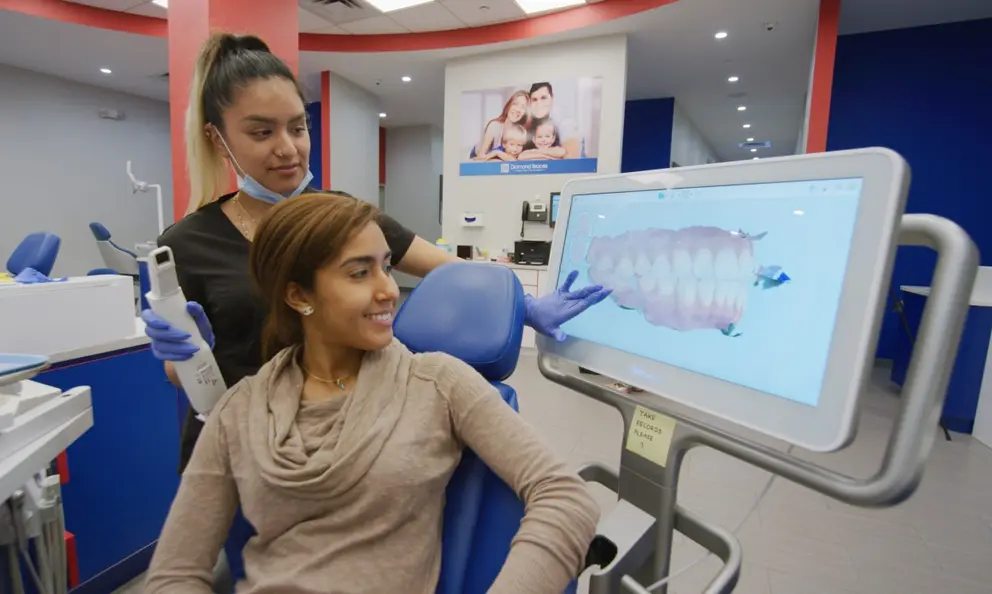 asistente dental de Diamond Braces muestra escaneo 3D iTero al paciente