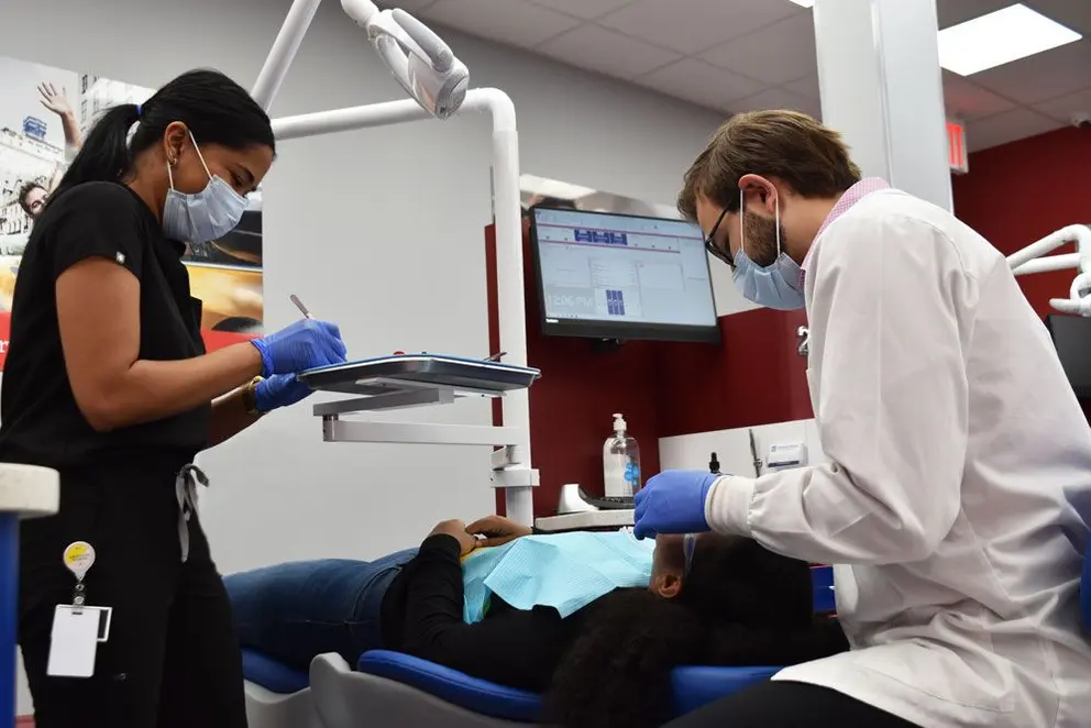 ortodoncista de diamondbraces y asistente trabajando con paciente de invisalign