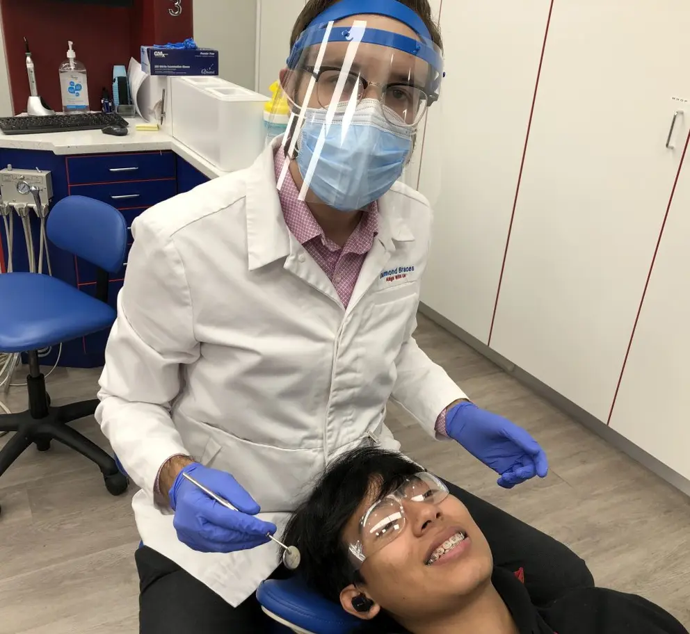 ortodoncista de Diamond Braces trabajando con un paciente con brackets en la oficina de Stamford, CT