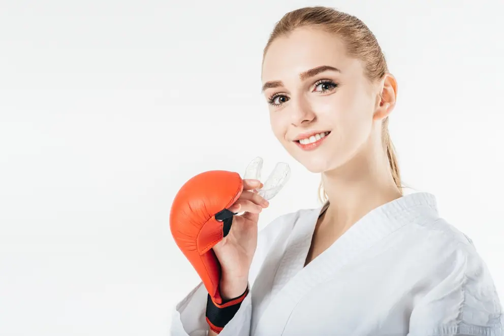 mujer kickboxer posando con protector bucal deportivo